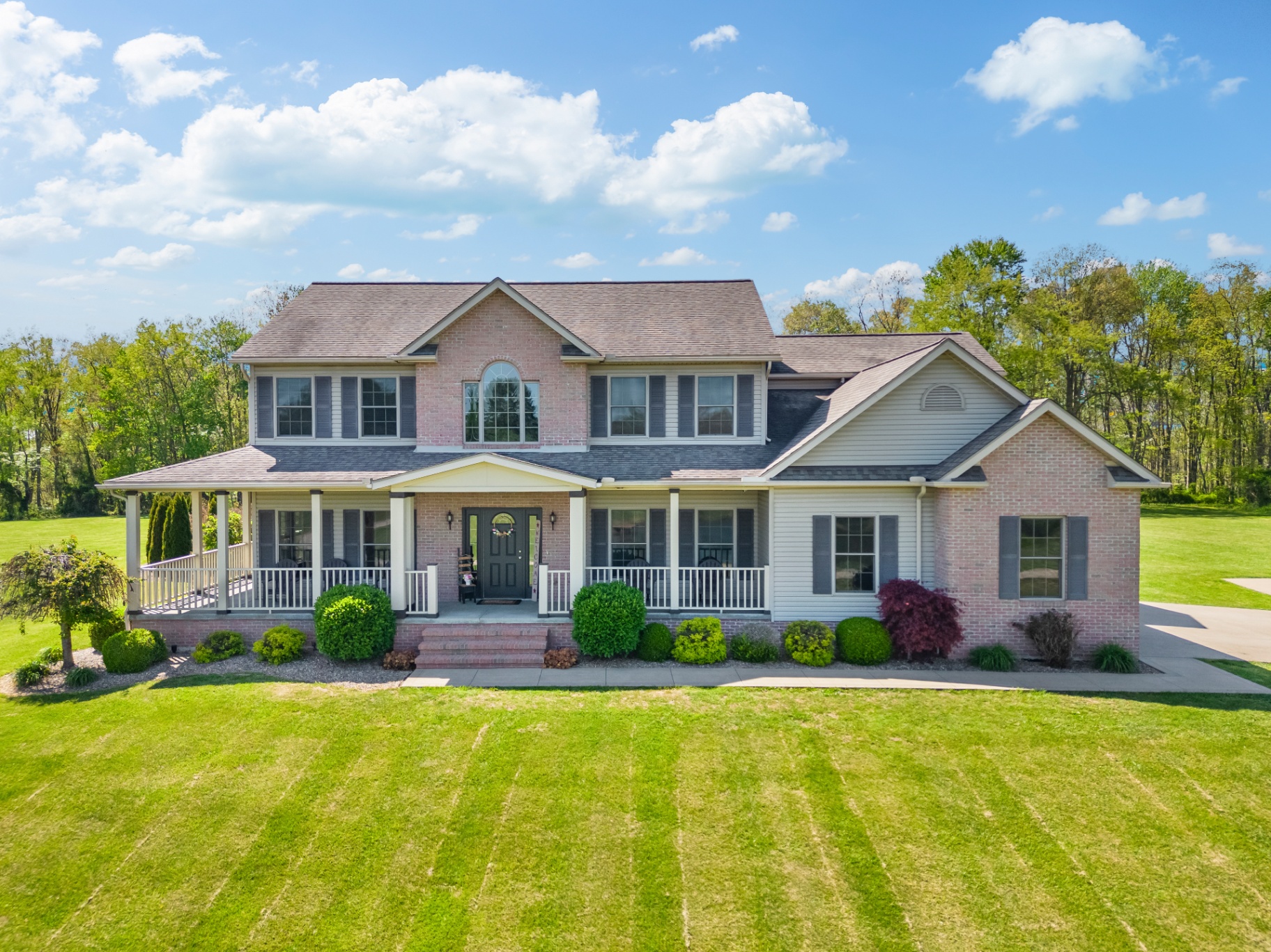 Front view of a two-story brick home with wrap-around porch in the Mid-Ohio Valley